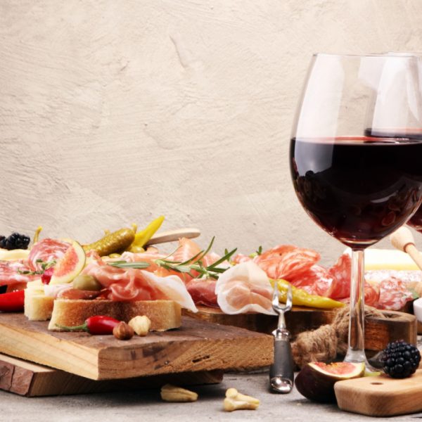 Italian antipasti wine snacks set. Cheese variety, Mediterranean olives, pickles, Prosciutto di Parma, pepper and salami